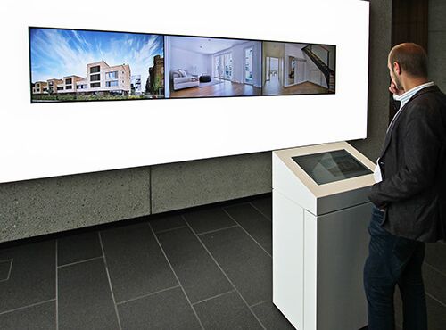 Touch-Terminal und Videowall in einem Ausstellungsraum.